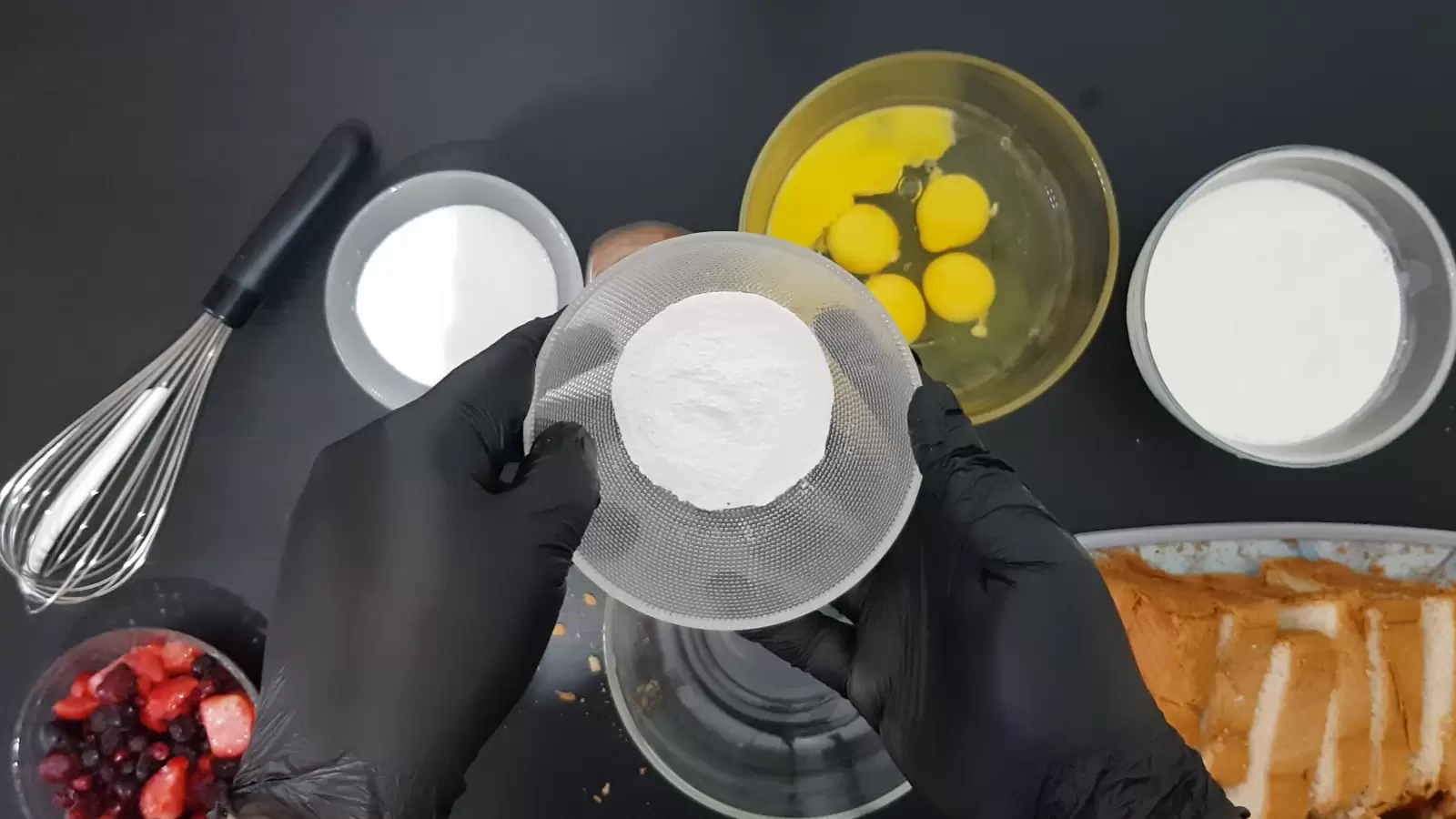 Bowl of heavy cream, bowl of eggs, bowl of sugar, bowl of vanilla sugar, bowl of berries, sliced ​​bread on cutting board, whisk