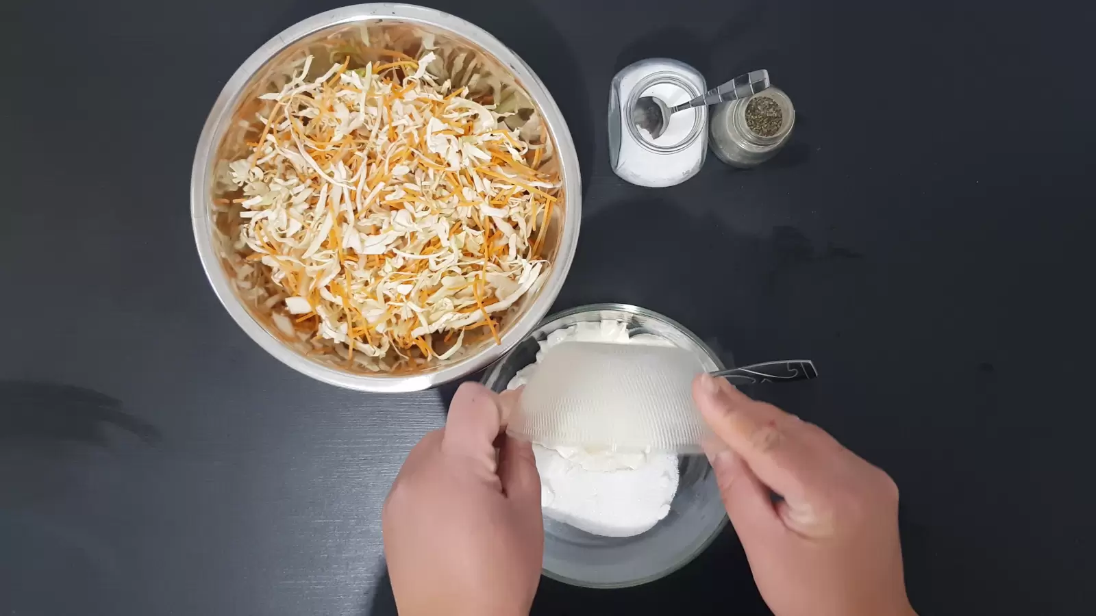 One bowl with cut carrots and cabbage, salt and pepper in a jar, a bowl with vinegar poured into a bowl with mayonnaise and sugar