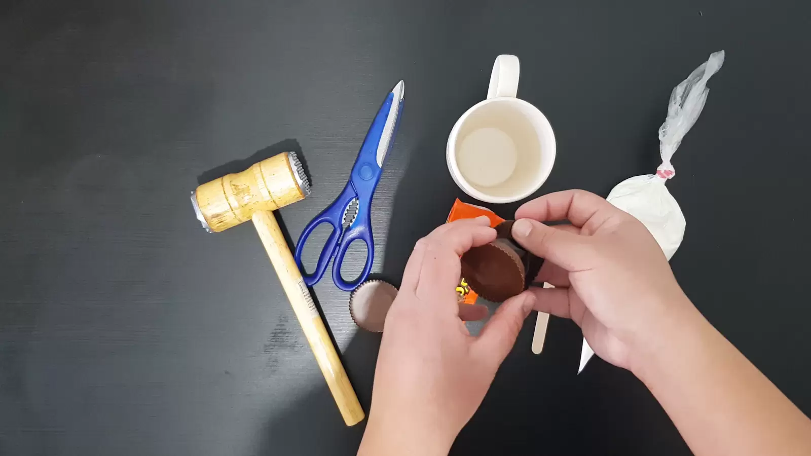 Sweet cream in a piping bag, mug, kitchen hammer, scissors, popsicle stick, Reeses