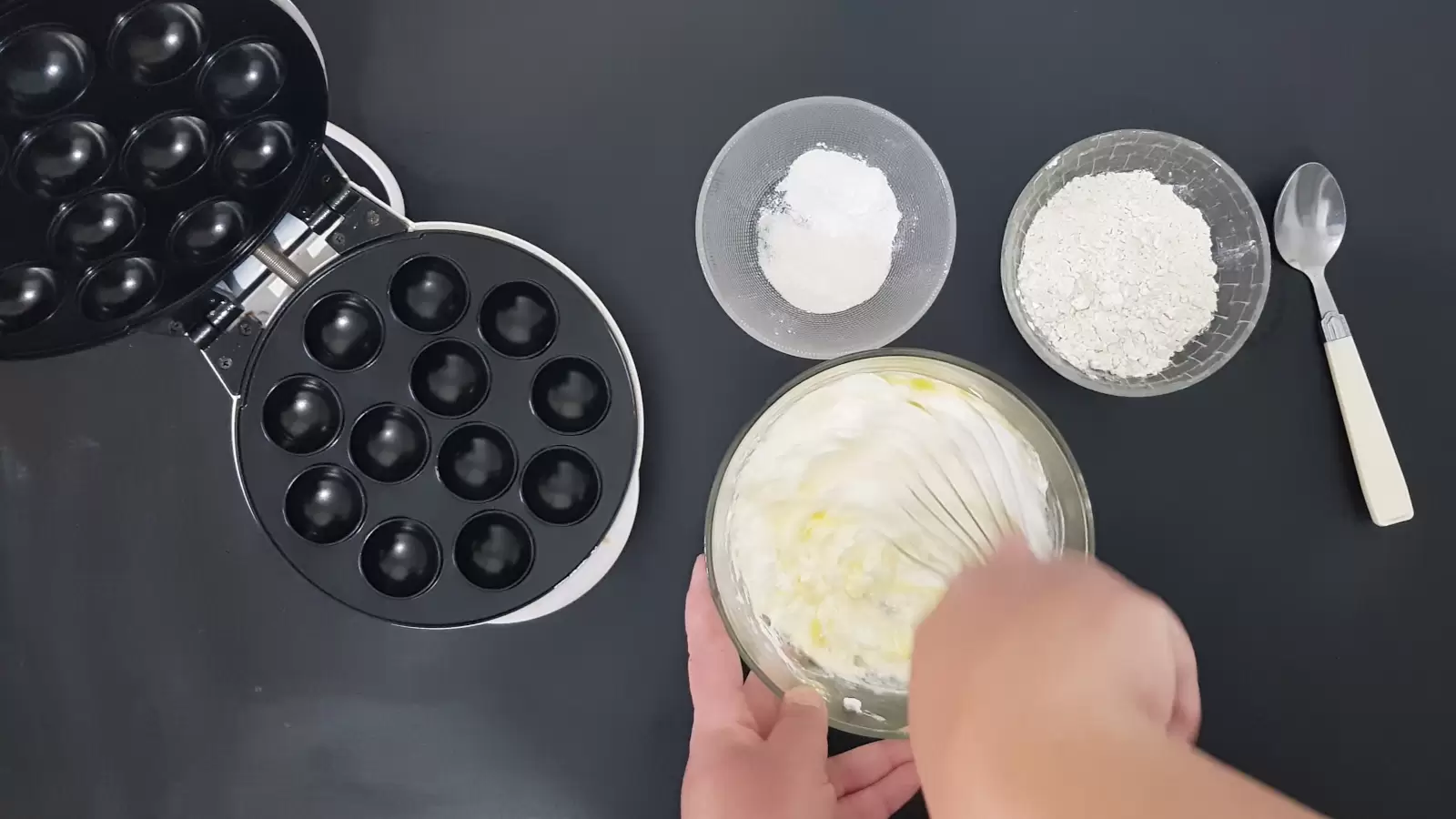 Mix in a bowl with a whisk, a bowl with flour, a bowl with baking powder and vanilla sugar, a spoon, a device for making pancake balls