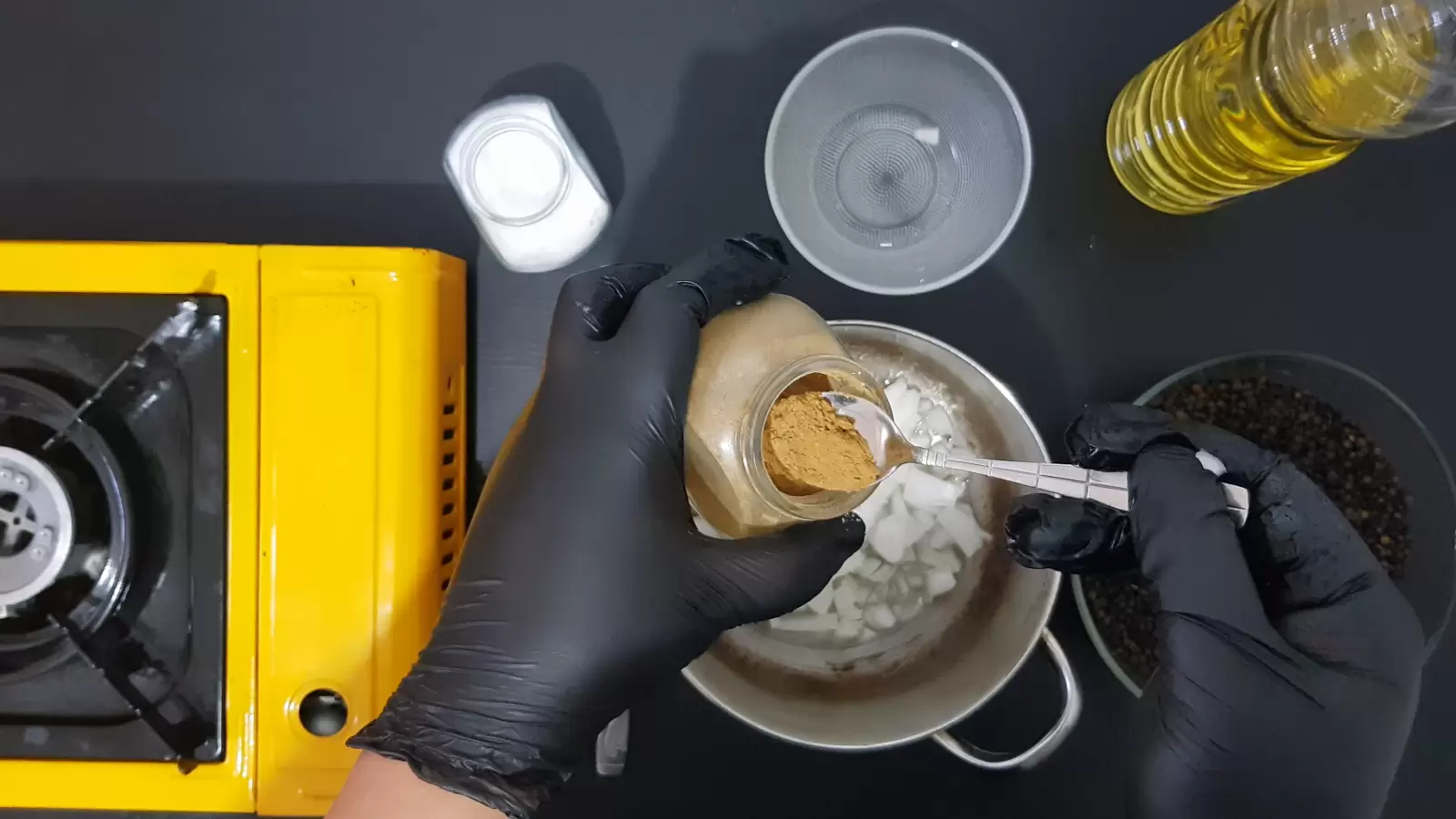 Bowl with lentils, empty bowl, jar of cumin with spoon, jar of salt, bottle of oil, gas jar, pot