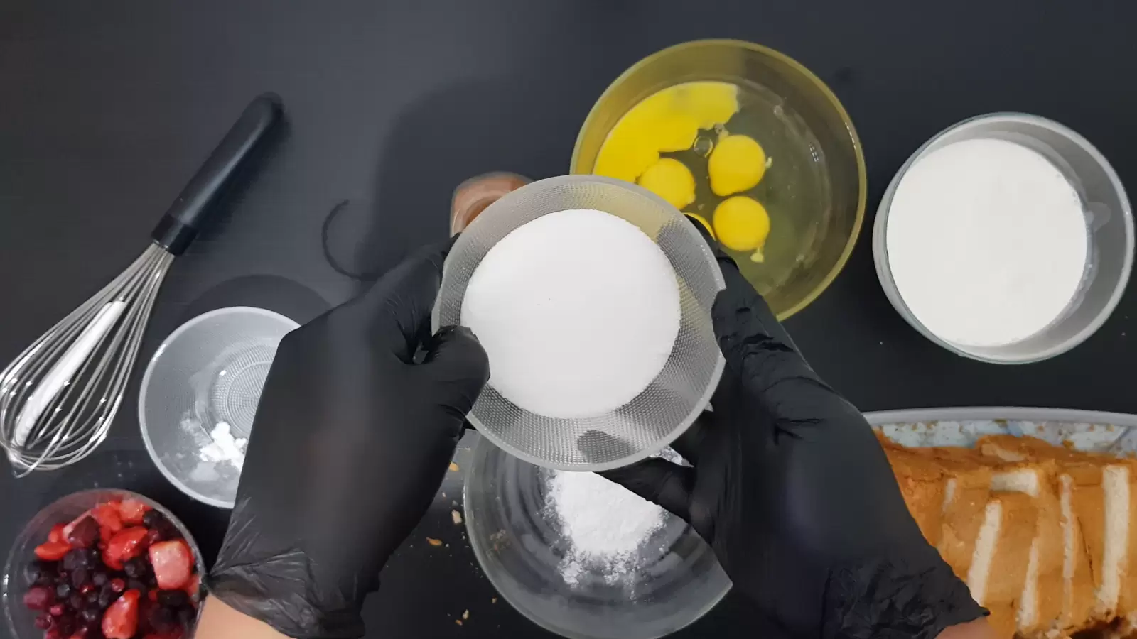 Bowl of heavy cream, bowl of eggs, bowl of sugar, empty bowl, bowl of berries, sliced ​​bread on cutting board, whisk