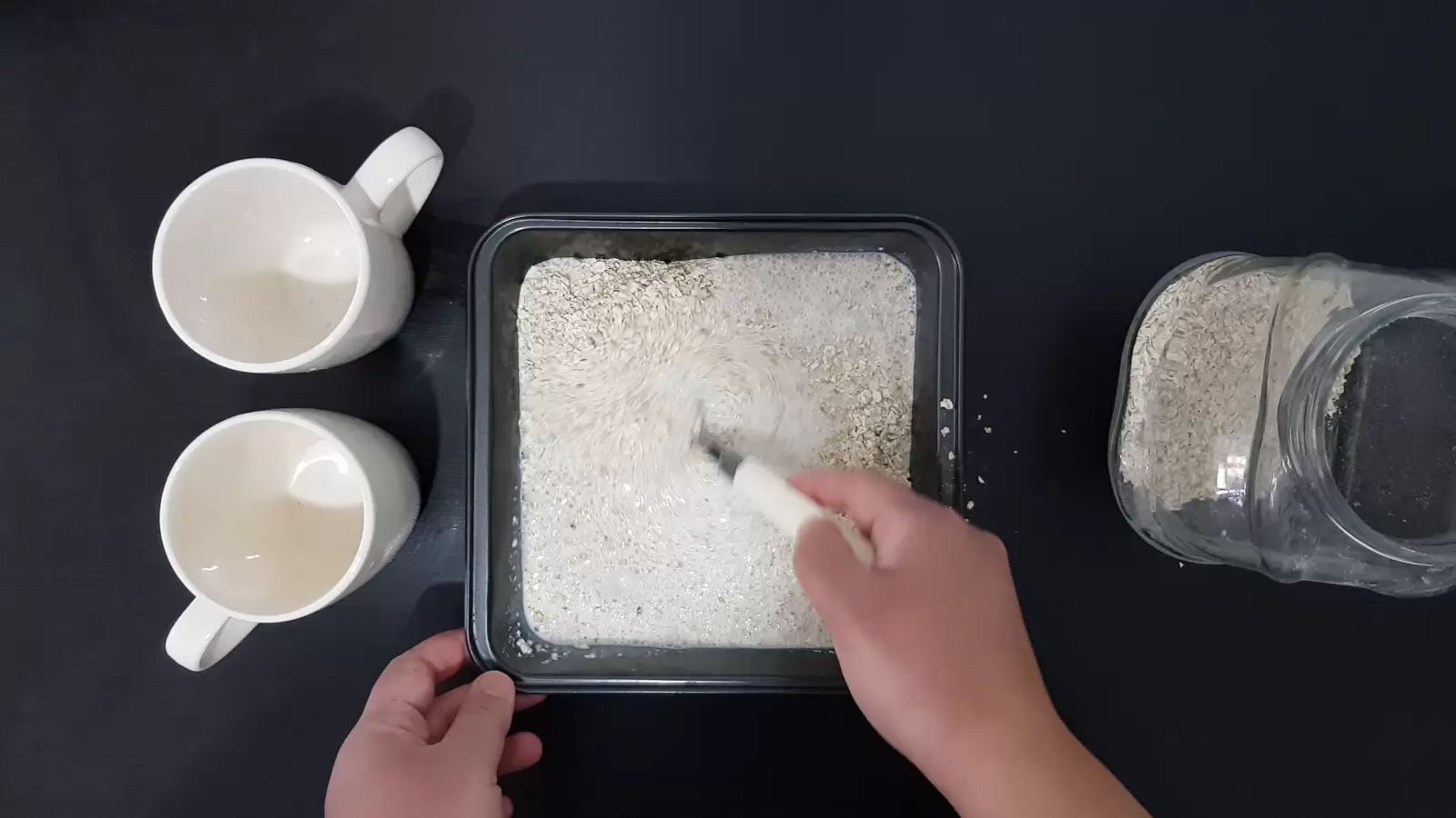 Two empty glasses, a mold with oats and milk, a spoon, a jar of oats