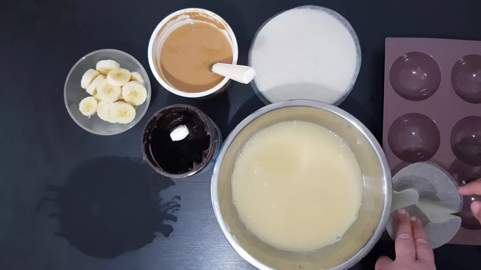 Rice paper in muffin pan, rice paper, peanut butter jar, chocolate jar, bowl of sliced ​​bananas, large bowl with mixture