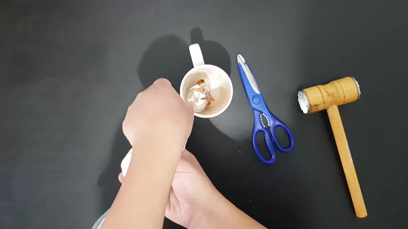 Kitchen hammer, scissors, Twix package in a cup and whipped cream poured into it