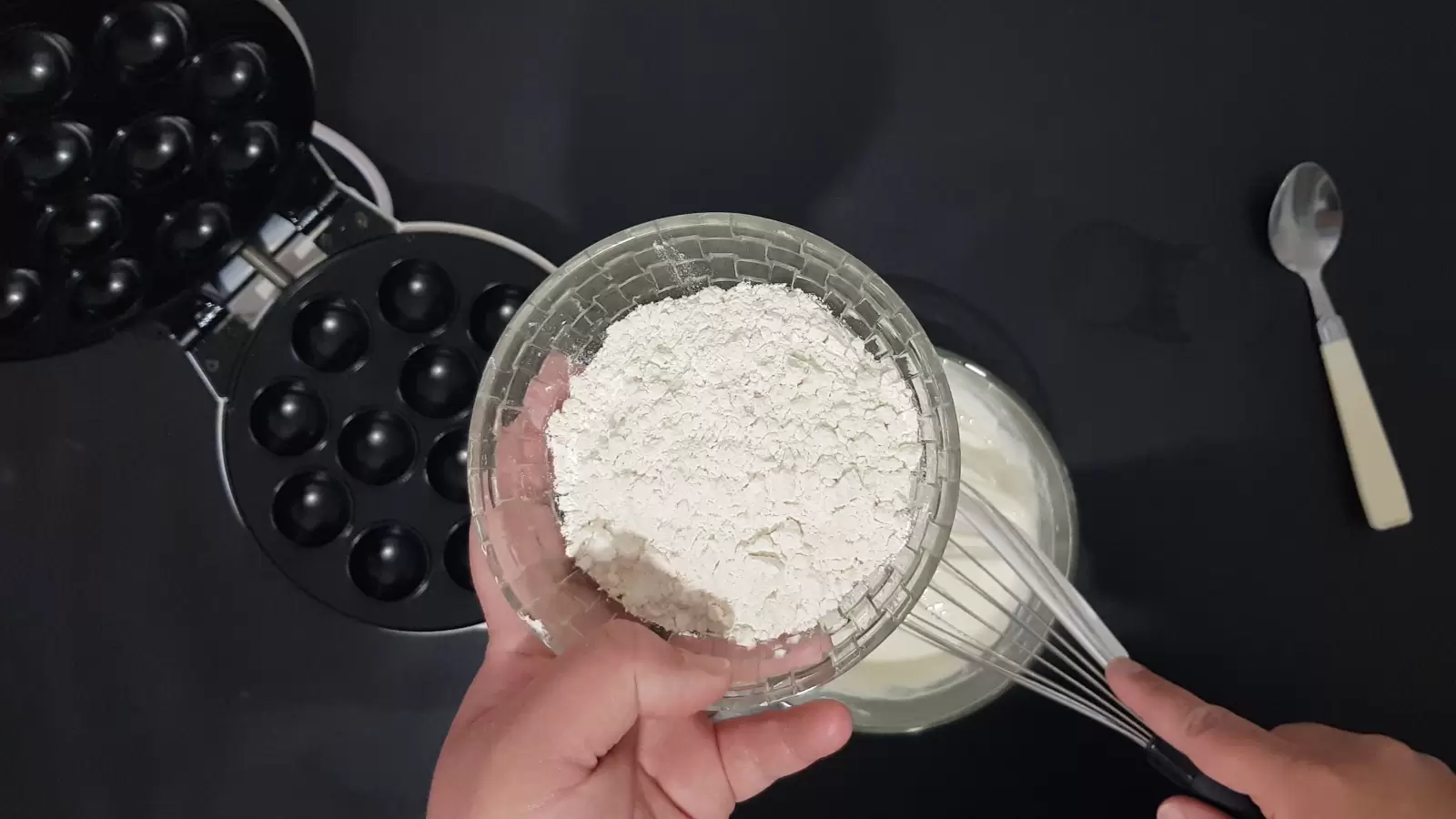 Mix in a bowl with a whisk, a bowl with flour, a spoon, a device for making pancake balls