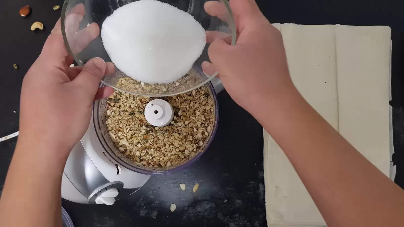 Filo sheets, blender with ground nuts, bowl with sugar