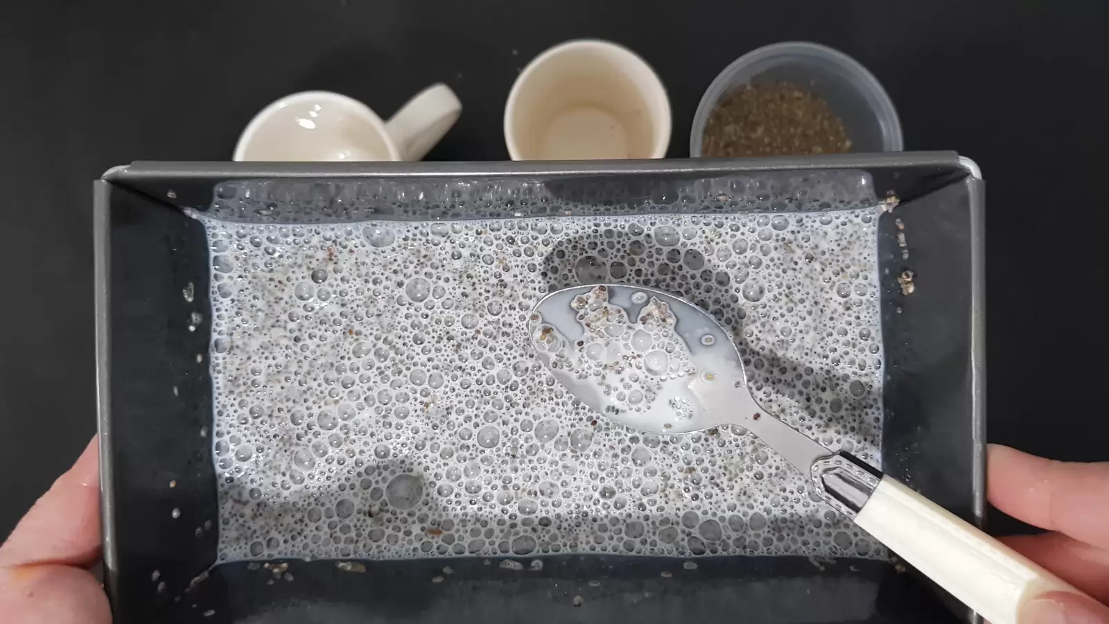 Two glasses, a box of chia, a mold with chia and milk, a spoon