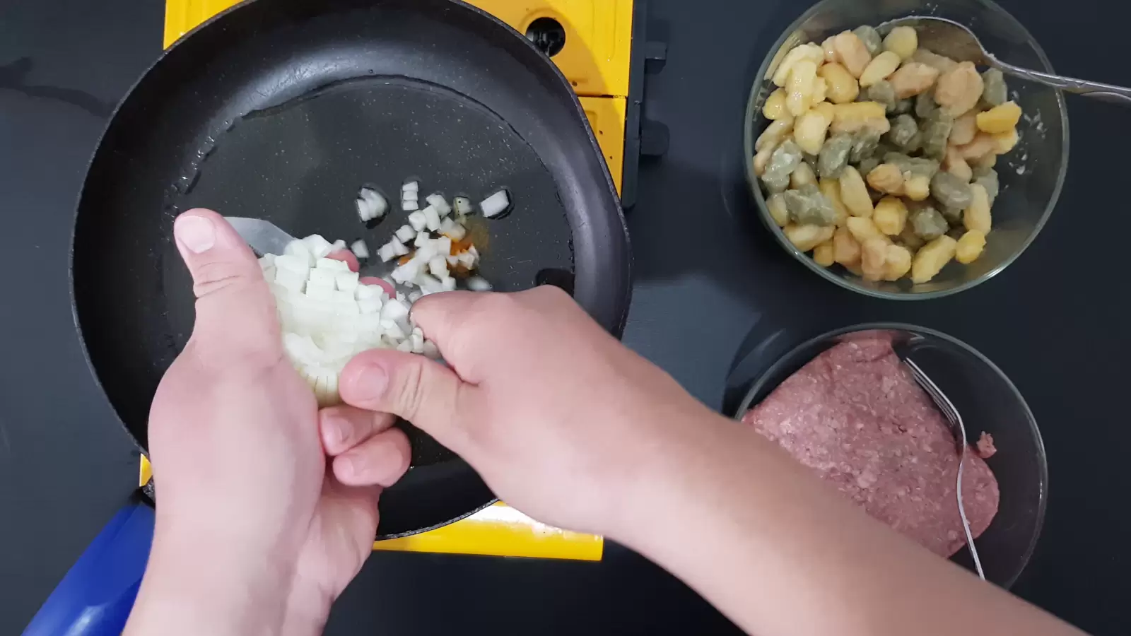 bowl with gnocchi, bowl with beef, pan, chopped onion, knife