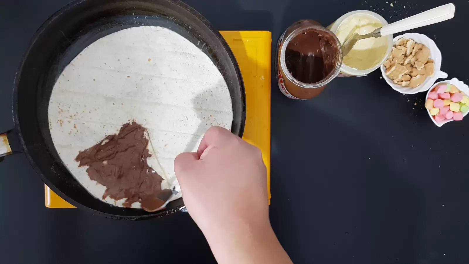 Biscuits bowl, white chocolate jar, Nutella chocolate jar, marshmallow bowl, tortilla in a pan with chocolate