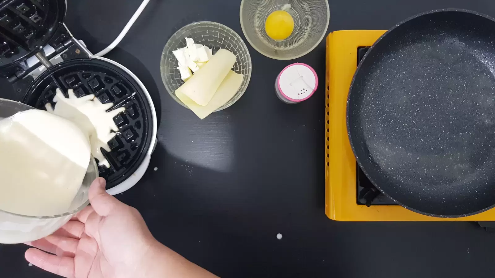 Bowl with egg, bowl with cheeses. pan. Mixture is poured into a waffle maker.