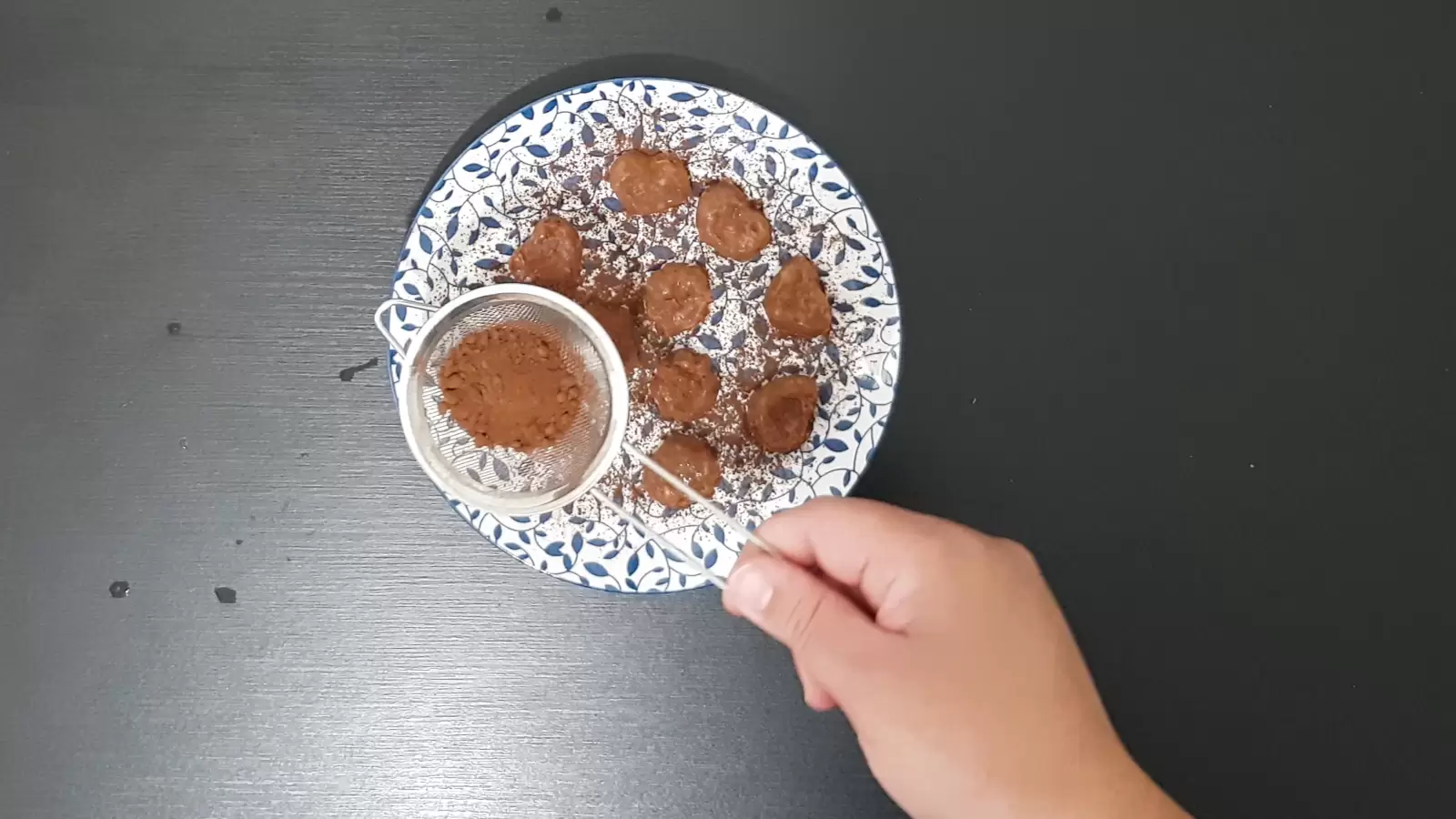 A plate with chocolate and banana truffles, cocoa powder sprinkled on top