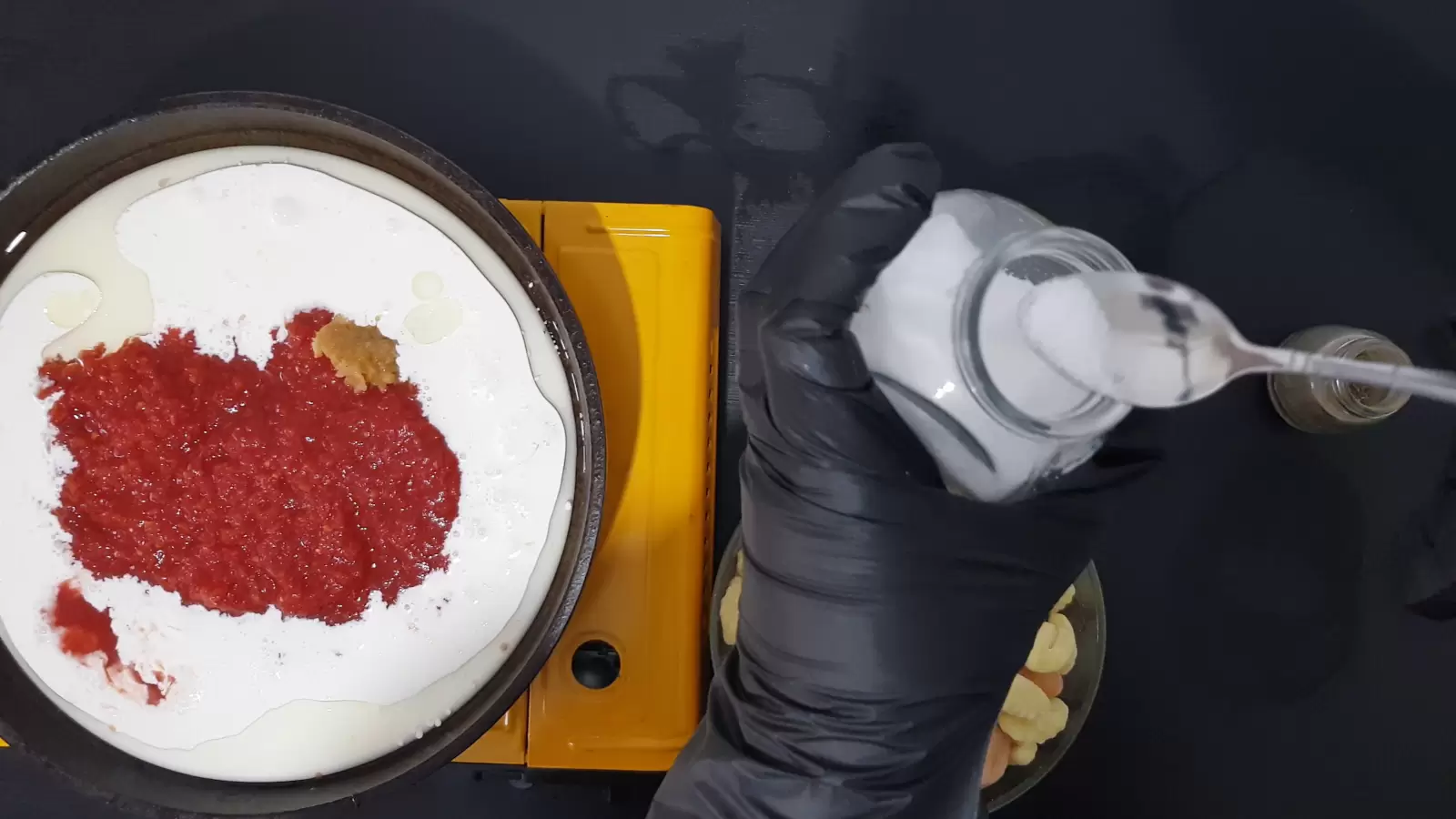 a jar of salt and a spoon, a pan with whipping cream and tomatoes Crushed