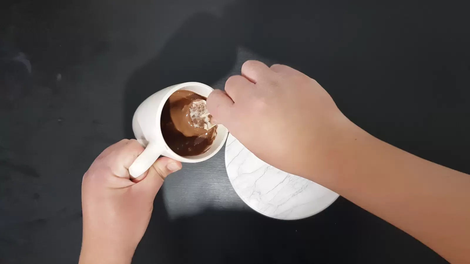 Twix ice cream in a cup with melted chocolate