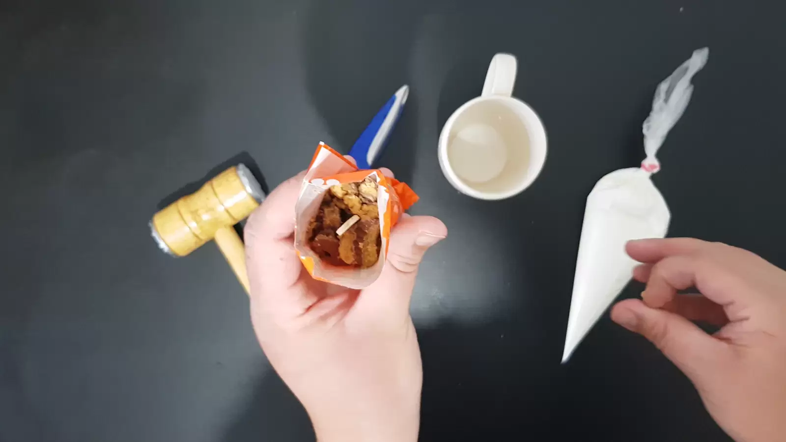 Sweet cream in a piping bag, mug, kitchen hammer, popsicle stick in a Reeses package
