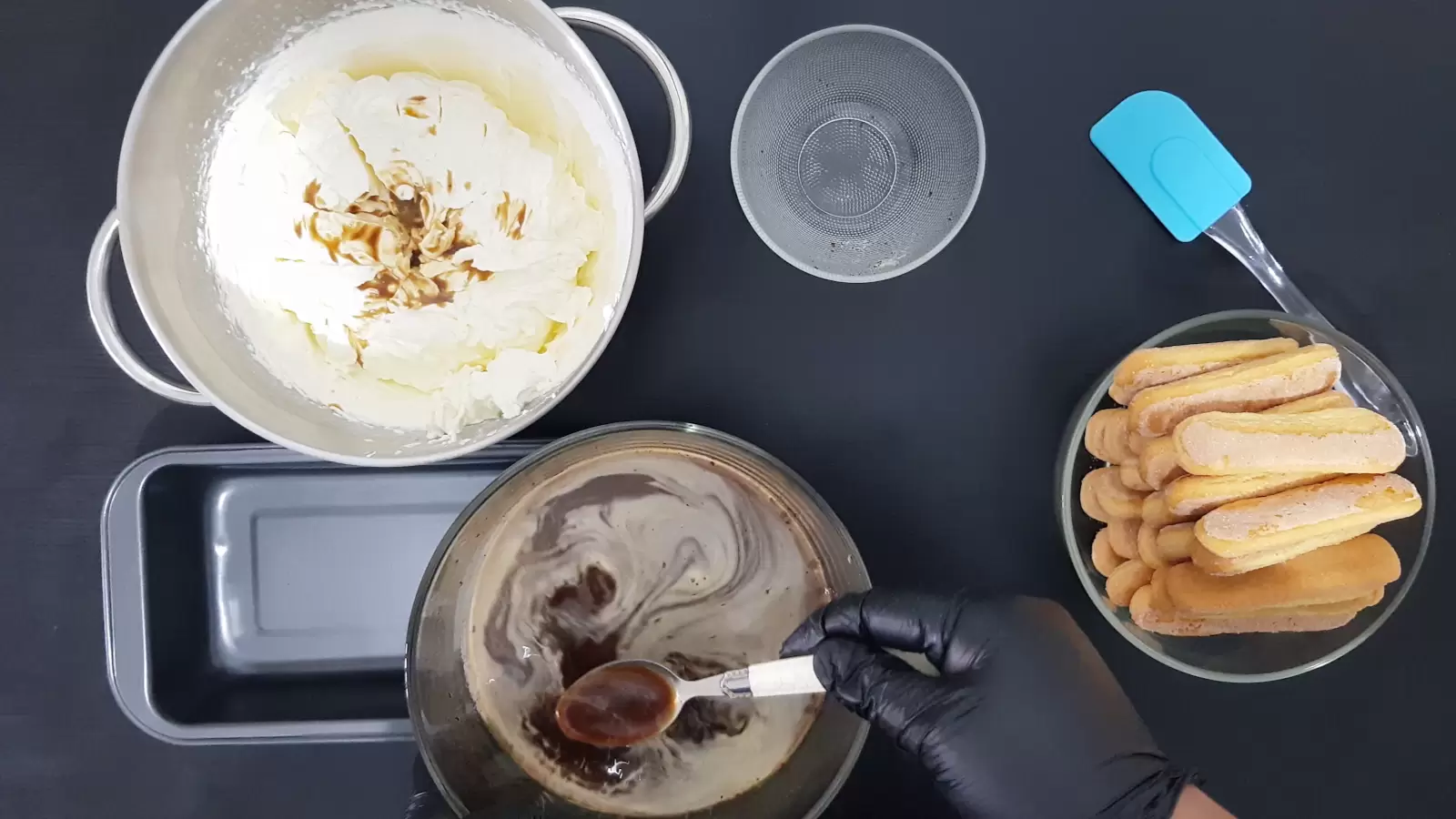 Bowl with coffee spoon and sugar, bowl with ladyfingers, mixer bowl with cream, pan, spoon