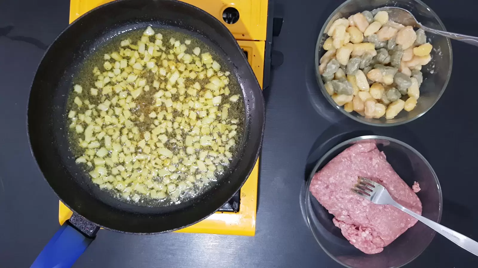 bowl with gnocchi, bowl with beef, pan with fried onions