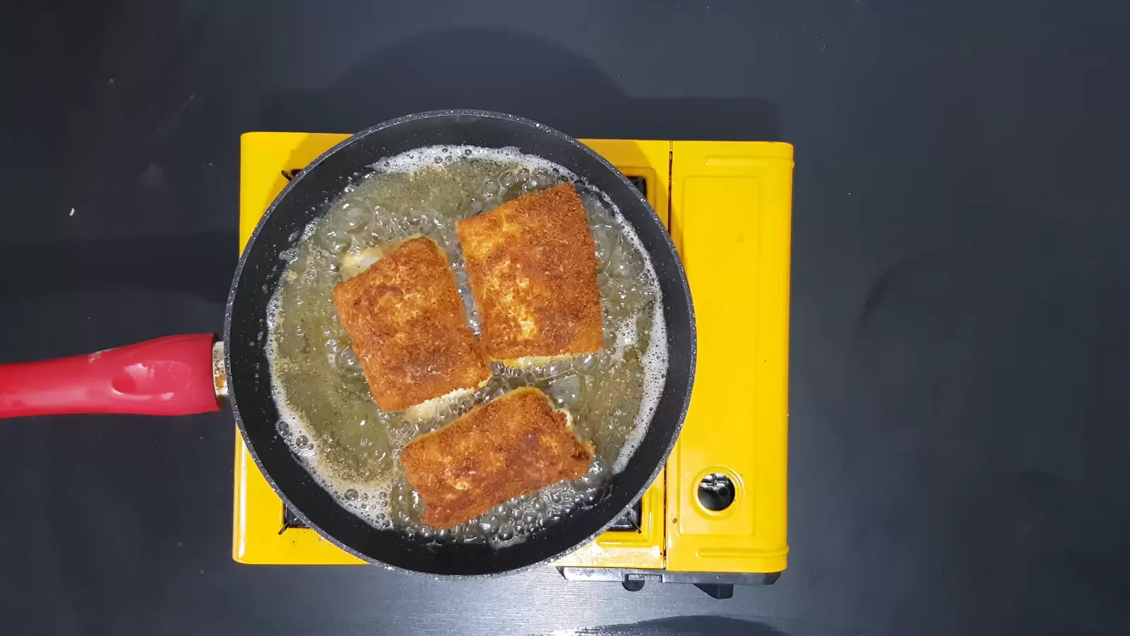 Frying pan with oil and chocolate-filled tortillas
