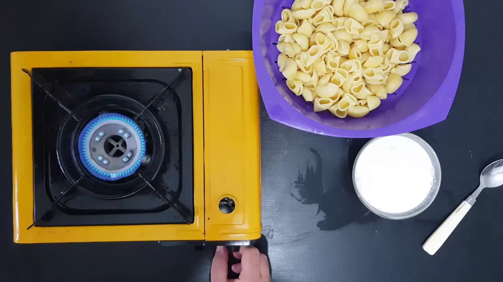 Bowl with pasta, bowl with whipped cream, spoon, fire