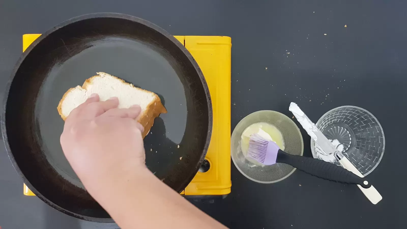 A bowl with butter and a brush. Empty bowl, bread on a pan