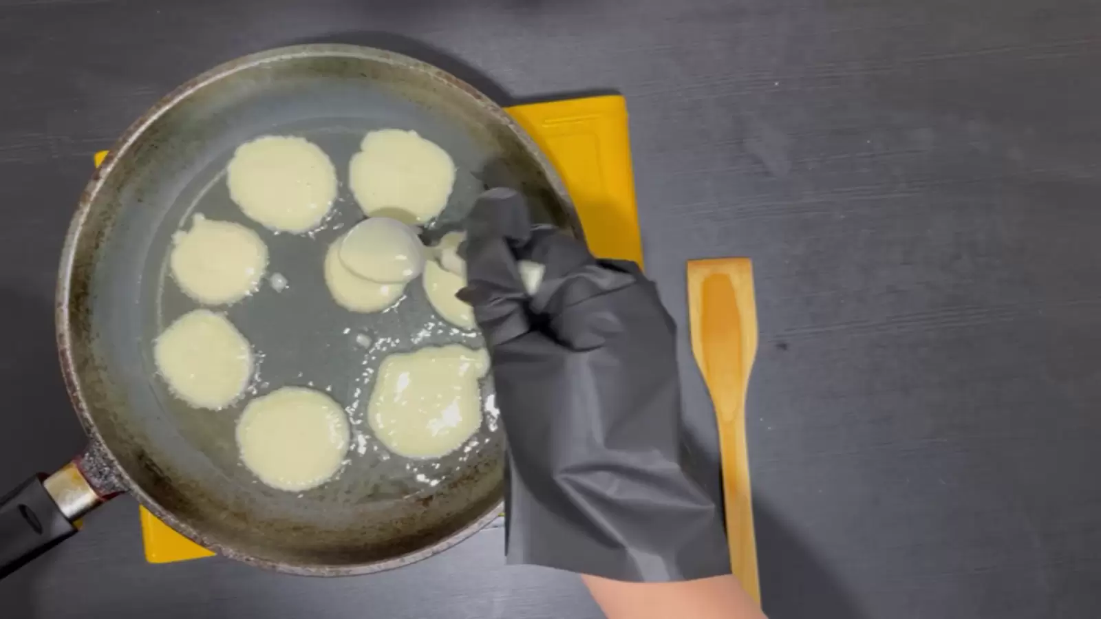 Pan with cheese pancakes, wooden spoon