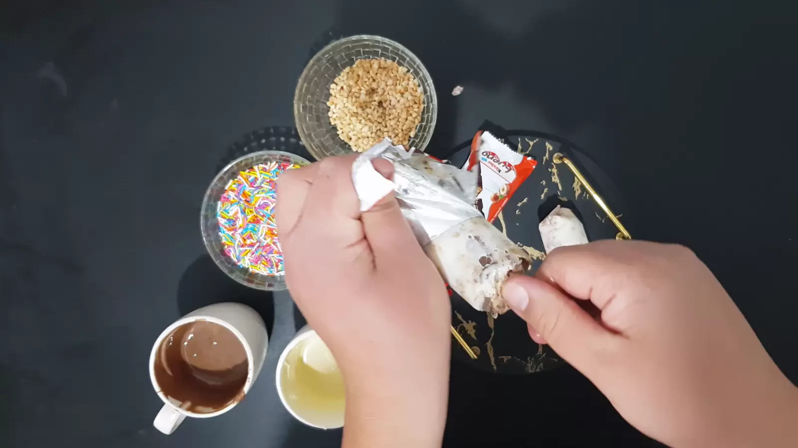 Nuts in a bowl, colorful candies in a bowl, a cup with melted chocolate, Kinder Bueno ice cream