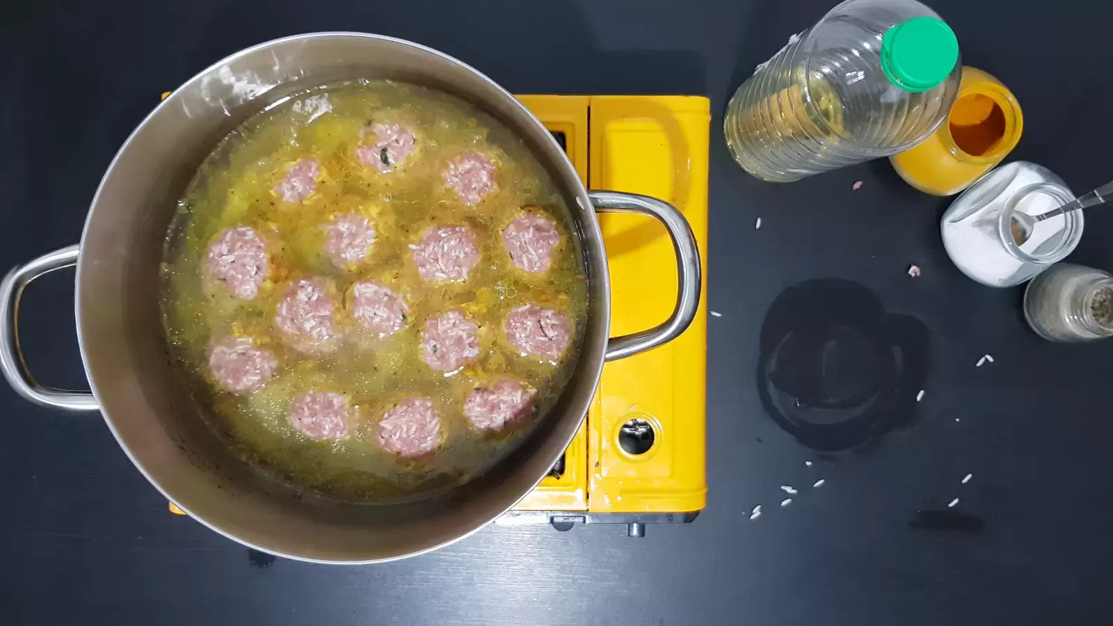 Porcupine Meatballs in a pot, jar of turmeric, jar of salt, Pepper jar, oil bottle