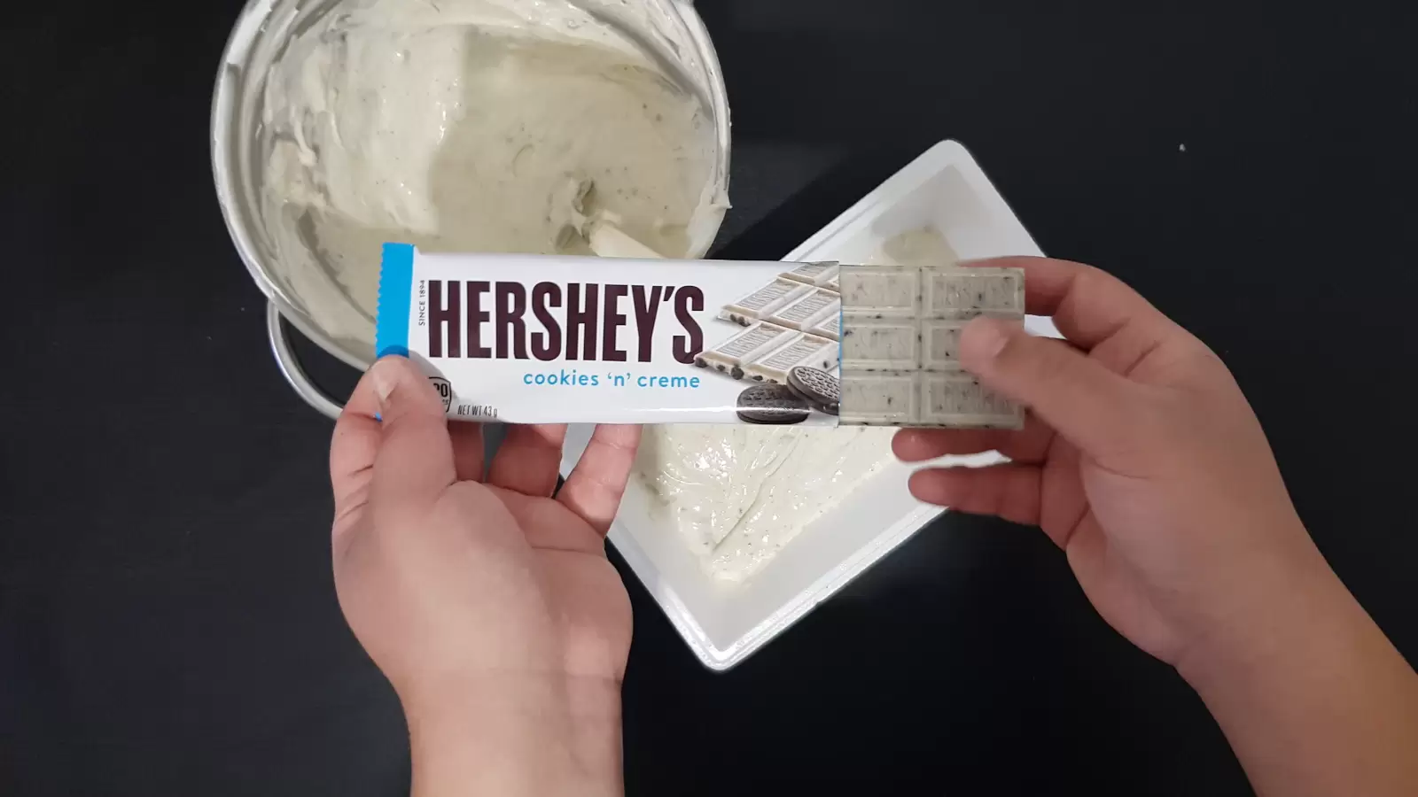 A bowl with ice cream mix, a pack of Hershey chocolates, an ice cream box and the ice cream mix