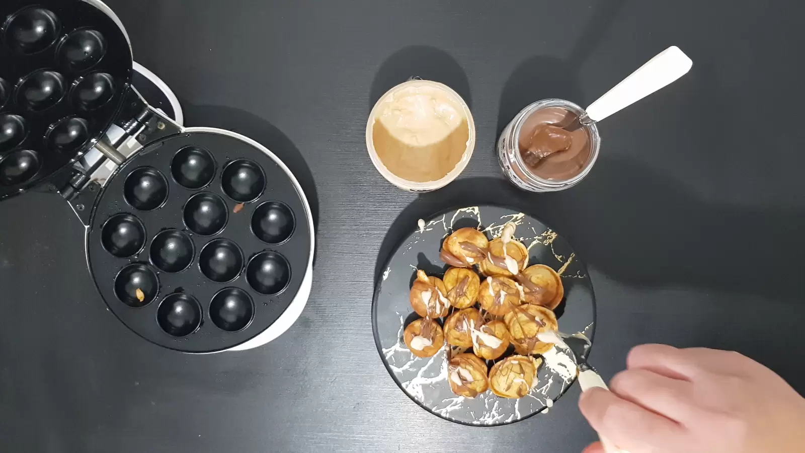 Pancake balls, Nutella and Kinder Bueno sauce, fork, a device for making pancake balls