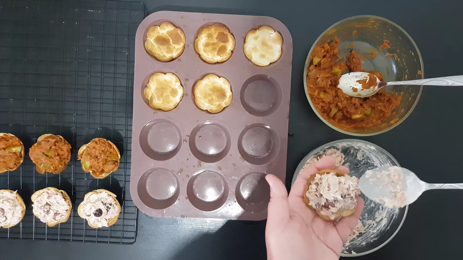 Bowl with tuna, bowl with tuna in tomato sauce, two spoons, muffin tin with tortillas, tortillas filled with tuna on a cooling rack