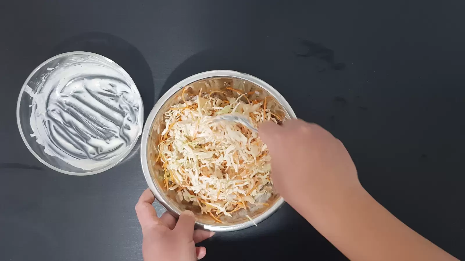 A bowl with empty sauce, a second bowl with cut carrots and cabbage