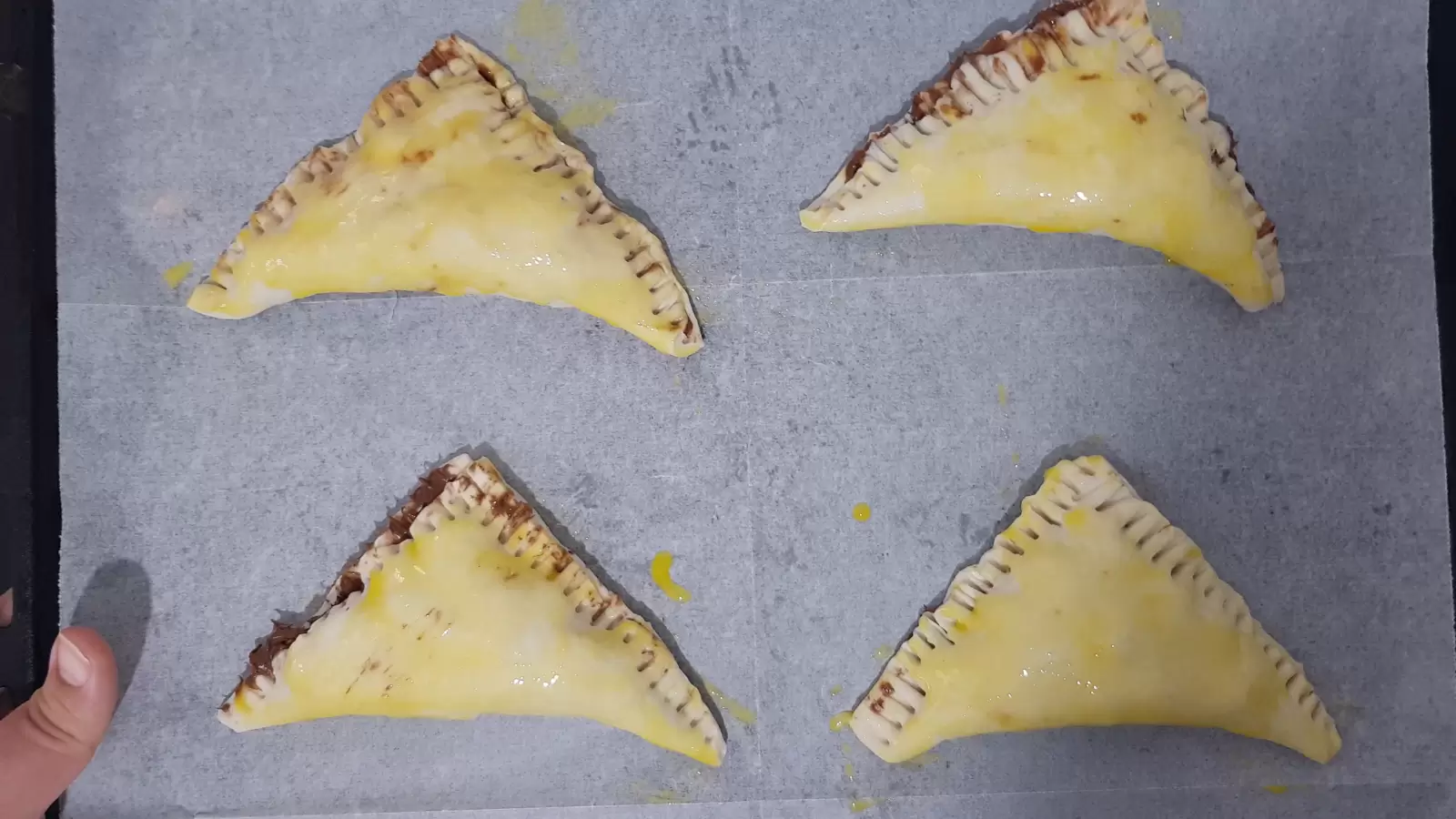 A mold for the oven with four puff pastry pastries