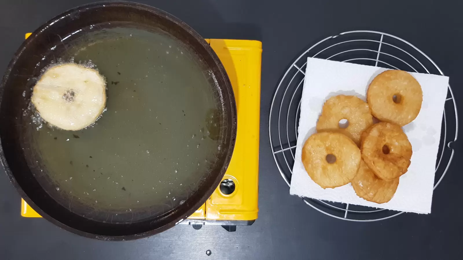 Pan with oil, doughnuts puff pastry, absorbent paper, cooling rack