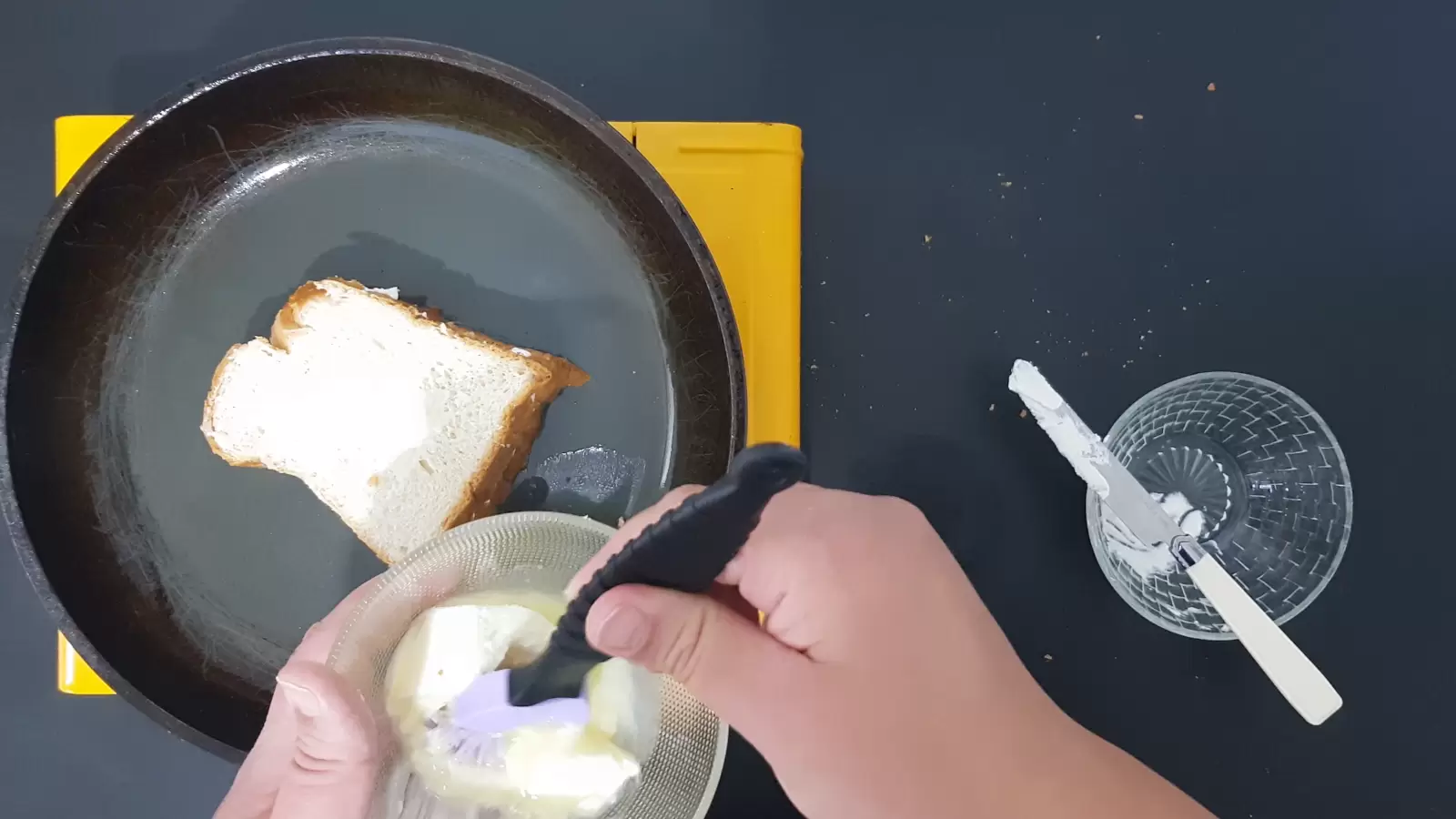 A bowl with butter and a brush. Empty bowl, bread on a pan