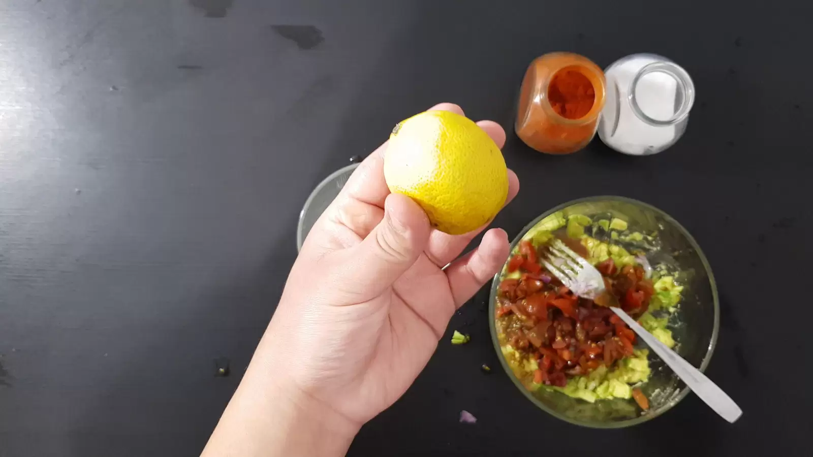 Spices, bowl with tomatoes and avocado, lemon