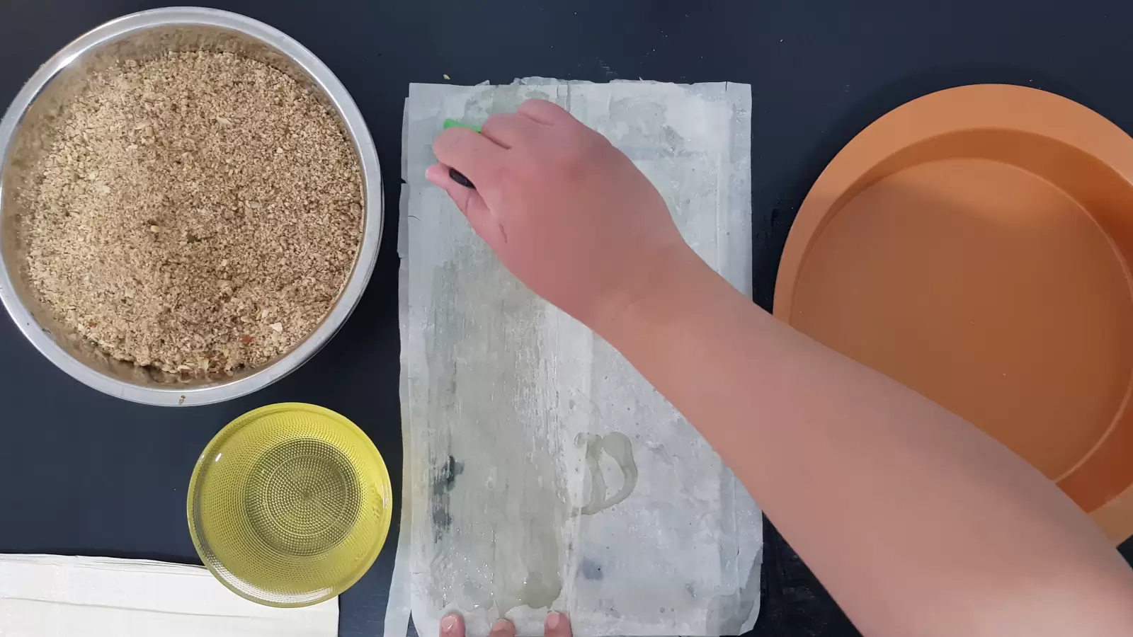 A pan for the oven, a bowl with oil and a brush for spreading on phyllo sheets, a bowl with a mixture of chopped nuts