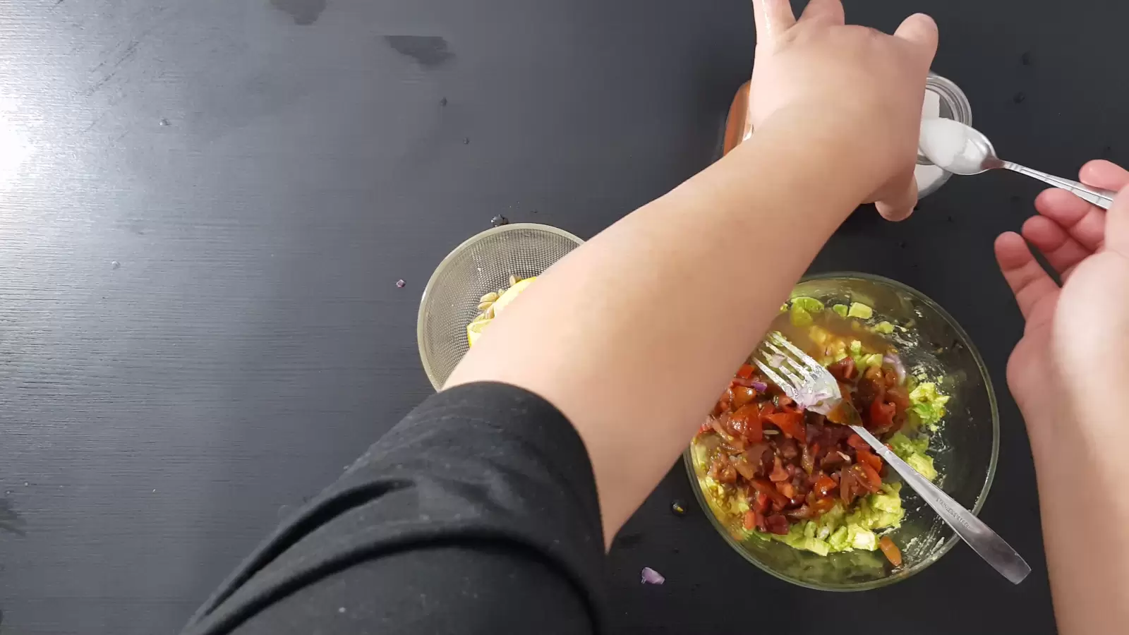 Spices, a bowl with tomatoes and avocado, a teaspoon of salt