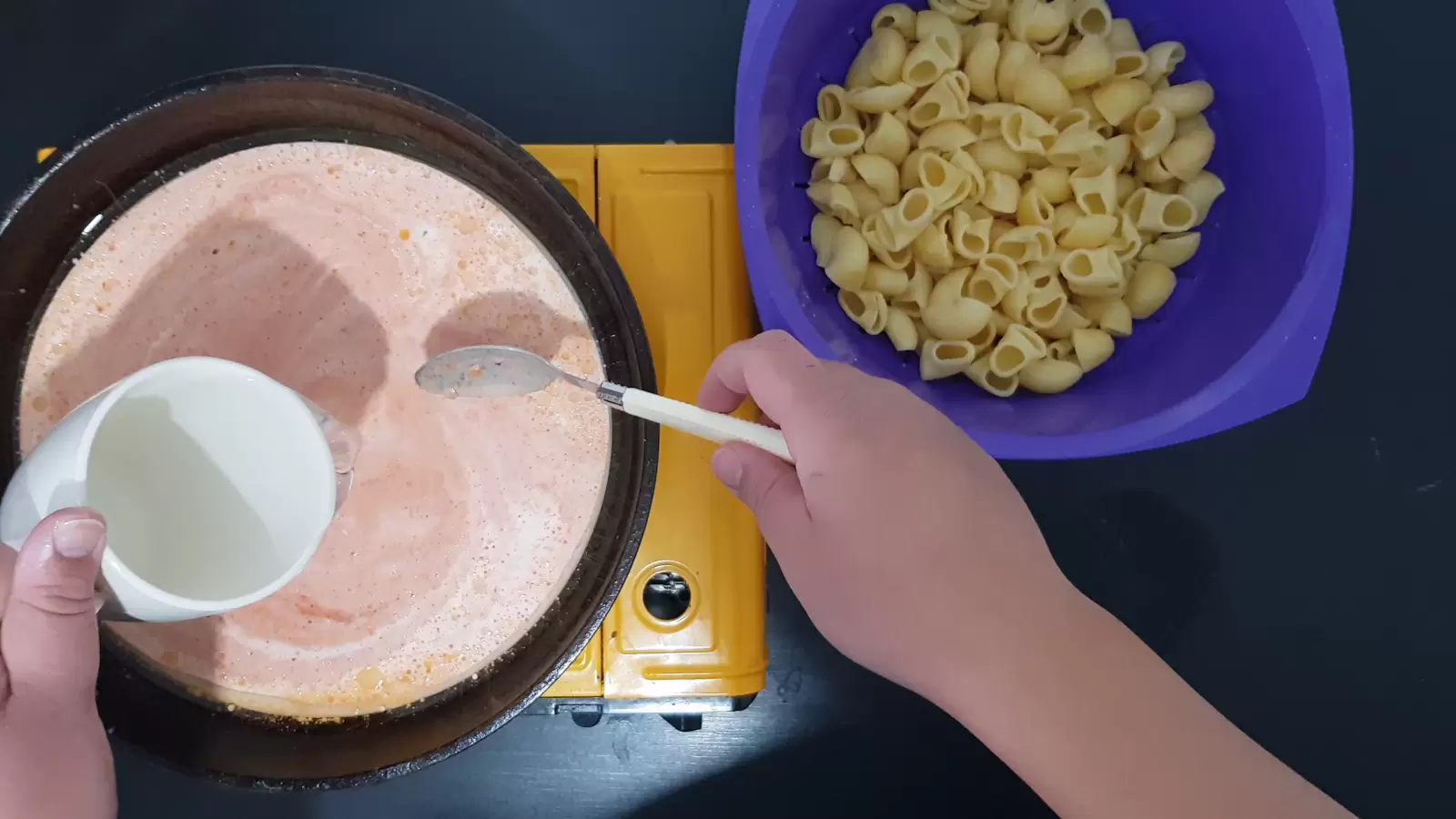 Bowl with pasta, pan with sauce, cup, spoon