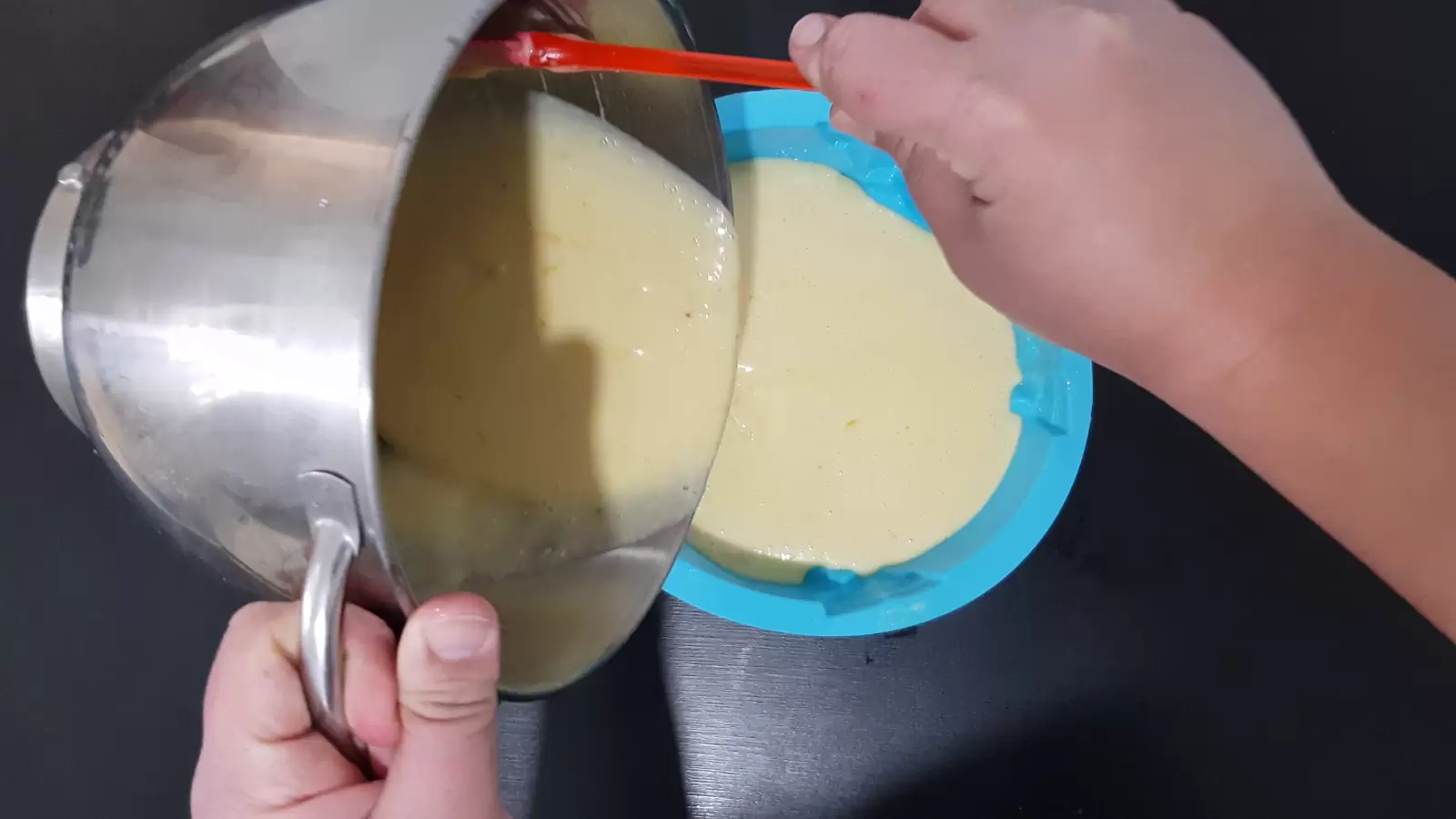 A mixer with a batter poured into a cake pan for the oven