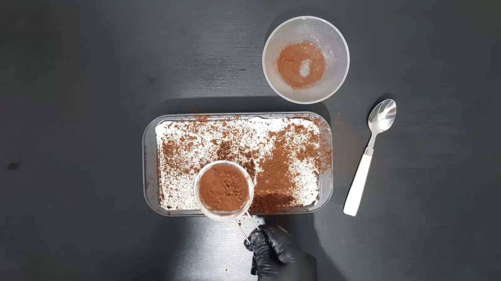 Tiramisu mold and bowl with cocoa powder, spoon