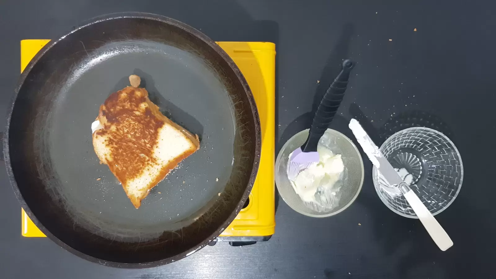 A bowl with butter and a brush. Empty bowl, bread on a pan