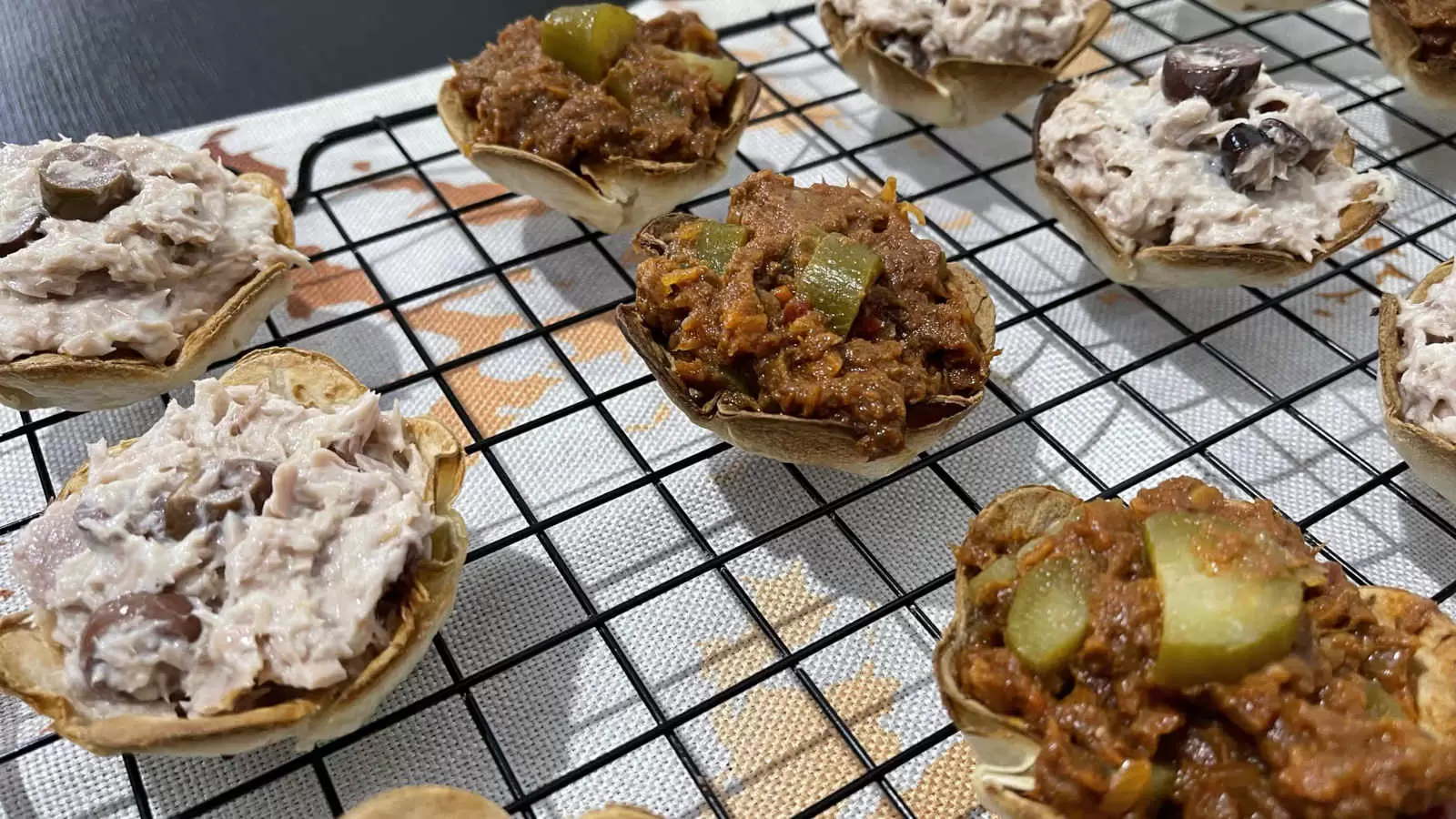 Tortilla flowers filled with tuna recipe on a cooling rack and under a napkin