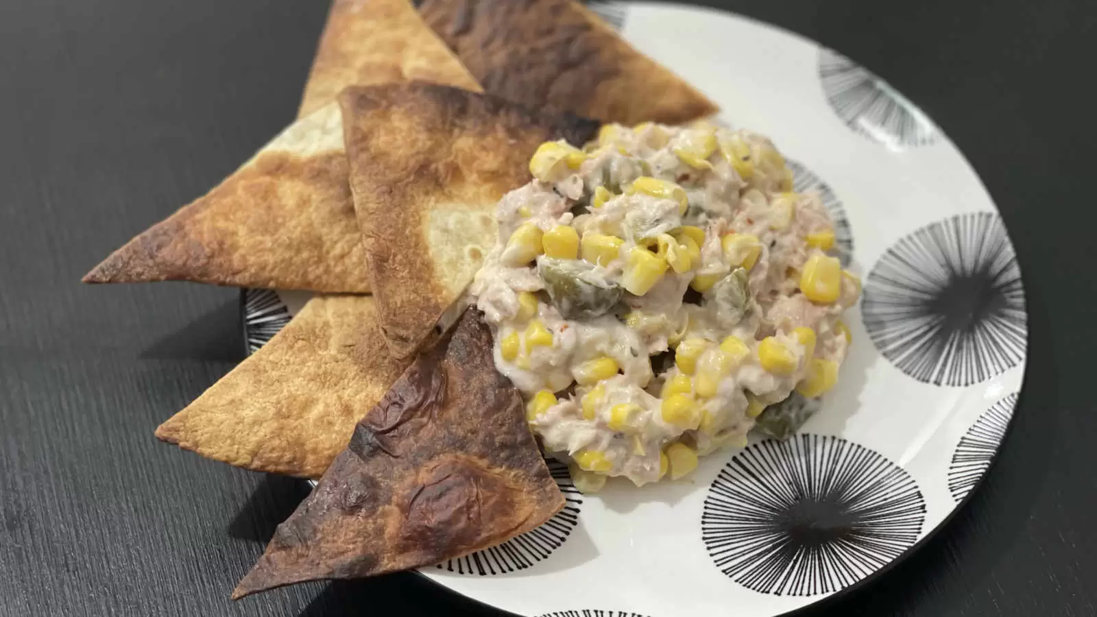 Tuna corn and mayonnaise salad on a plate and tortilla triangles