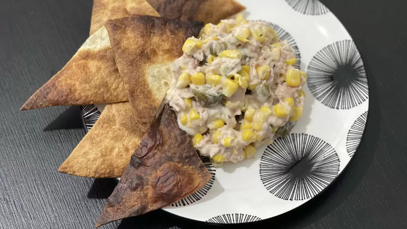 Tuna corn and mayonnaise salad for lunch on a plate and tortilla triangles