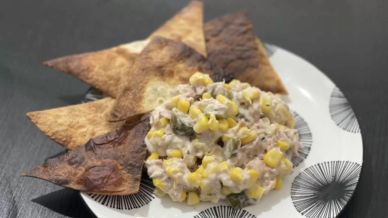 Tuna corn and mayonnaise salad recipe on a plate and tortilla triangles