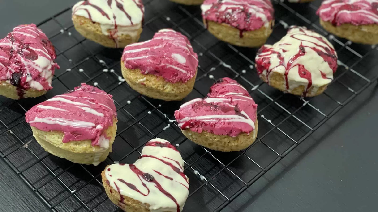 Vanilla and berry cupcakes on a cooling rack