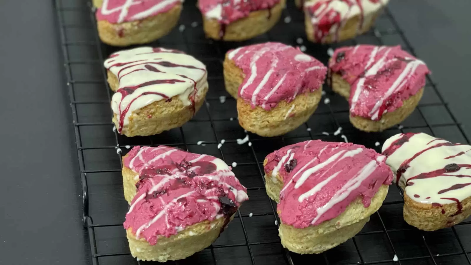 Vanilla and berry cupcakes on a cooling rack