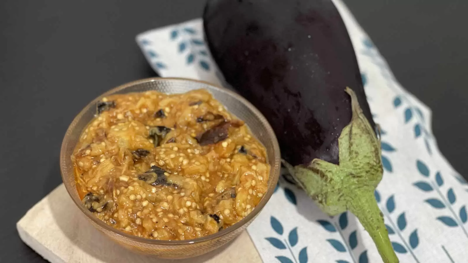 Eggplant on a napkin vegan eggplant salad in a bowl on a wooden tray