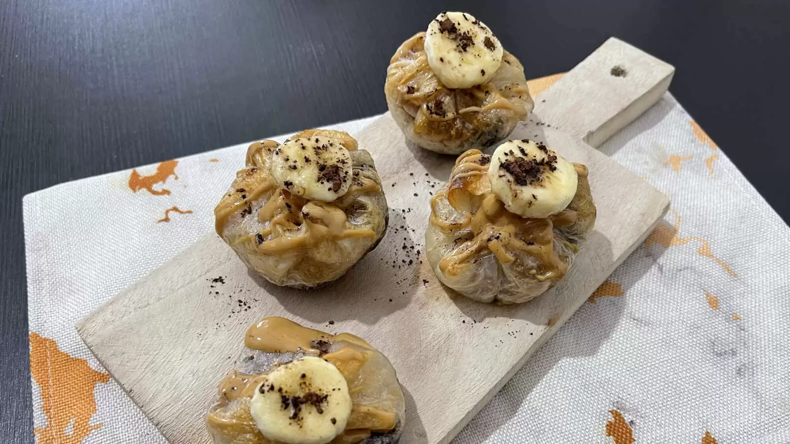 Four units of vegan Peanut Butter Chocolate and Banana Rice Paper on a wooden tray